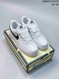 Pair of white Nike Air Force 1 low-top sneakers with navy Swooshes on a shoe box