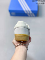 Rear view of the white sneaker showing the padded heel and gum-colored outsole edge.