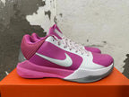 Side view of a pink and white Nike basketball shoe with a silver Swoosh and pink midsole.