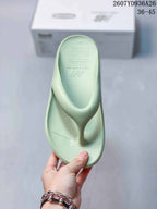 Top view of a pale green thong sandal showing the textured footbed, toe post, and New Balance branding.