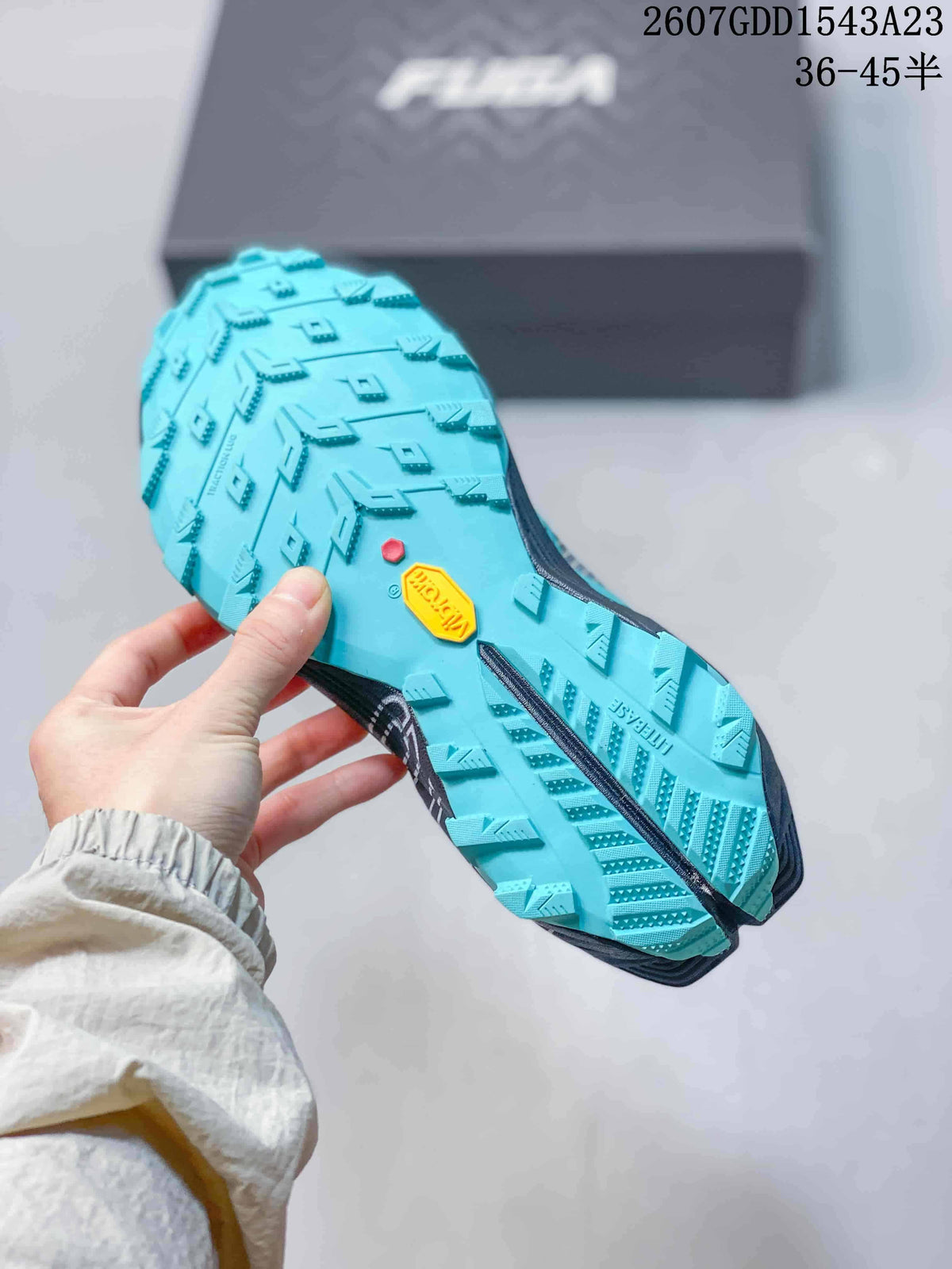 Close view of the teal outsole showing multidirectional tread blocks and a yellow Vibram-branded insert.
