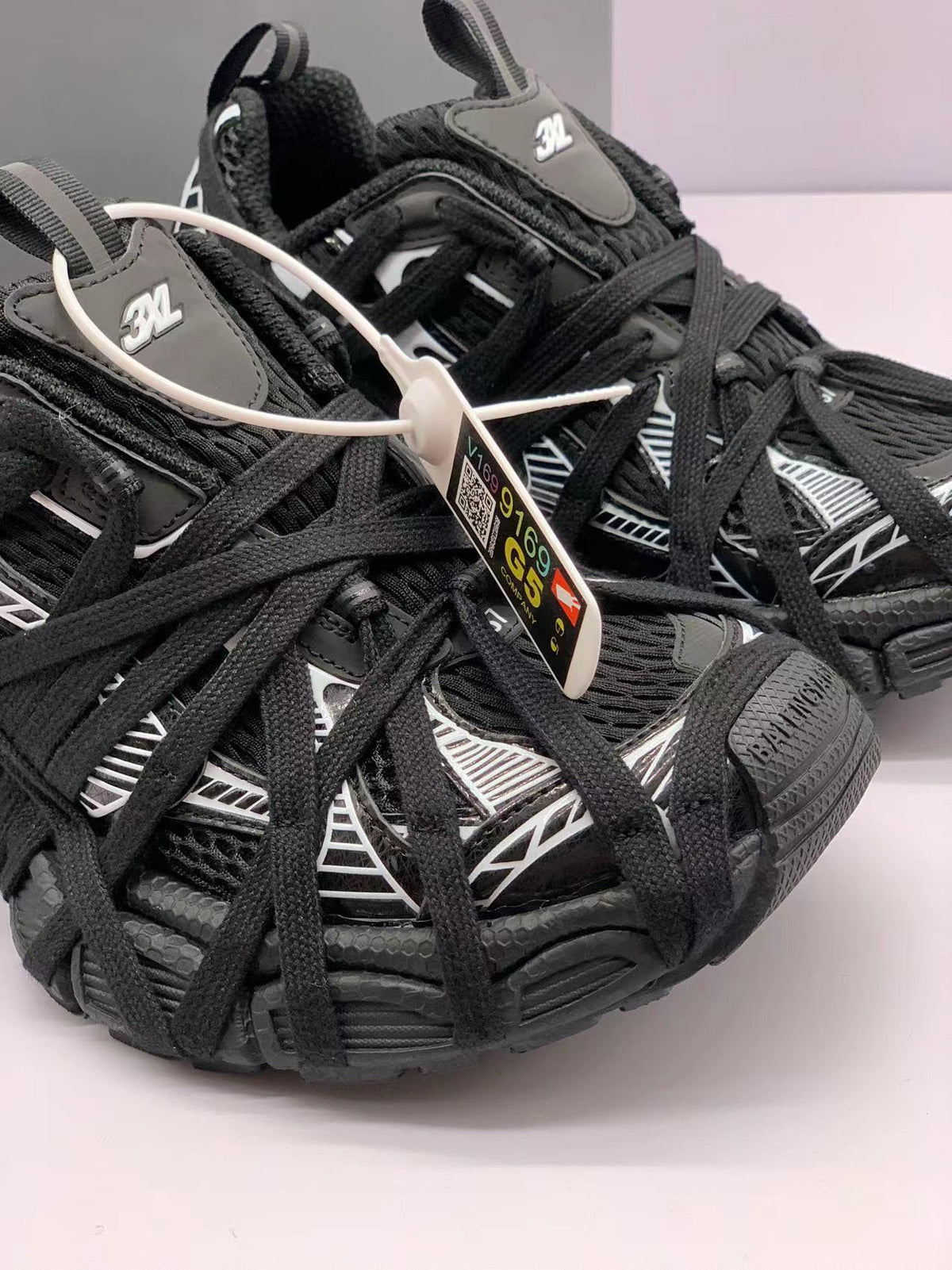 Close-up of the layered black upper, contrasting graphic panels, laces and 3XL tongue markings.