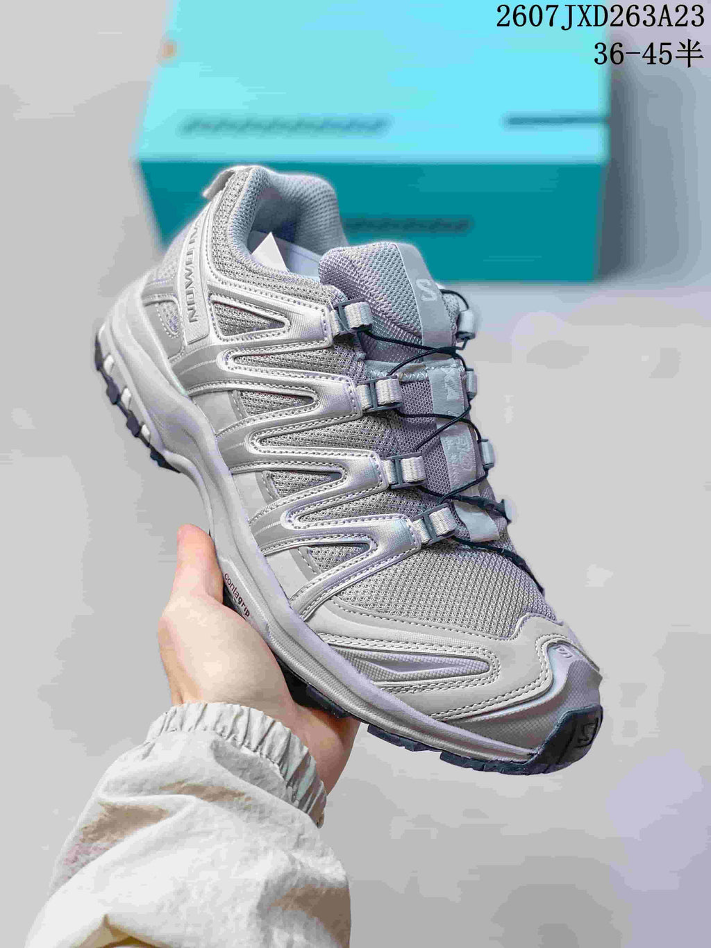 Angled side view of the Salomon XA Pro 3D sneaker showing the gray and silver upper, cord fastening system, padded collar, and dark outsole.