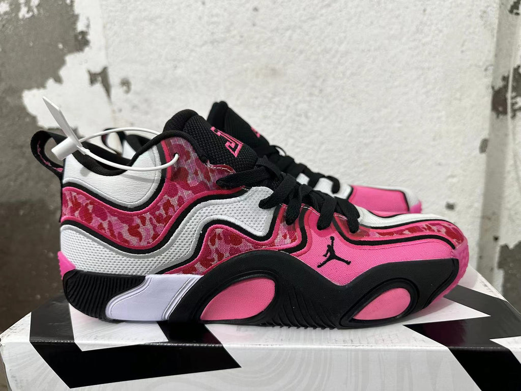 Side view of a Jordan sneaker showing pink and patterned panels and a black outsole