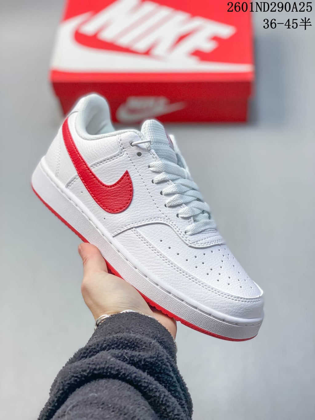White Nike Court Vision Low sneaker with a red Swoosh and red outsole accents.