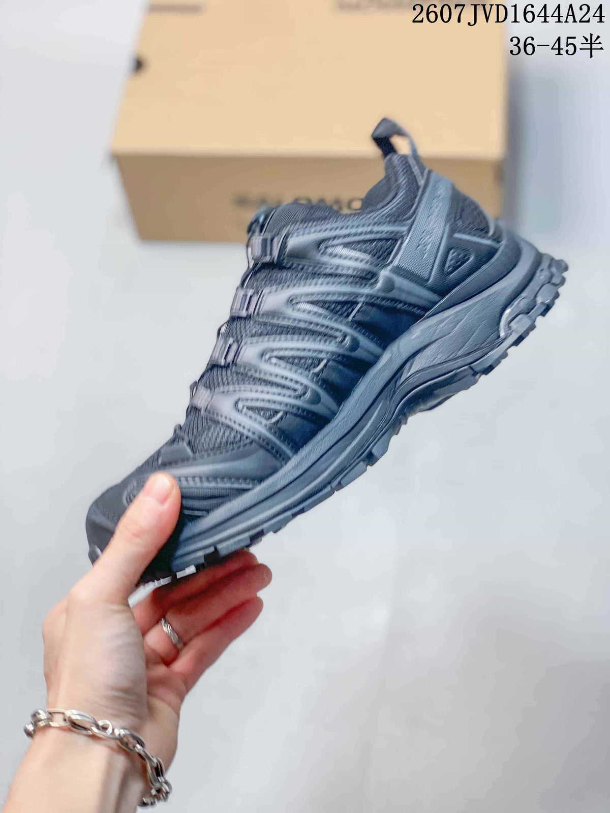 Side profile of the black Salomon sneaker showing layered panels, mesh sections and a lugged sole.