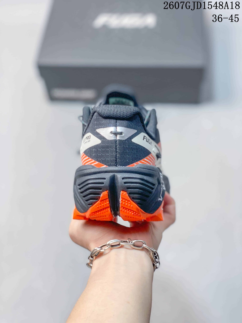 Rear view showing the structured black heel, orange outsole sections, and FUGA branding.