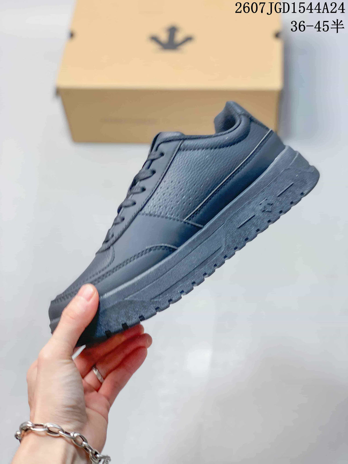 Side profile of a black low-top sneaker showing the layered upper panels and textured outsole.