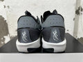 Rear view of black and grey low-top shoes with perforated heel panels and white midsoles.
