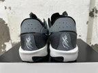 Rear view of black and grey low-top shoes with perforated heel panels and white midsoles.