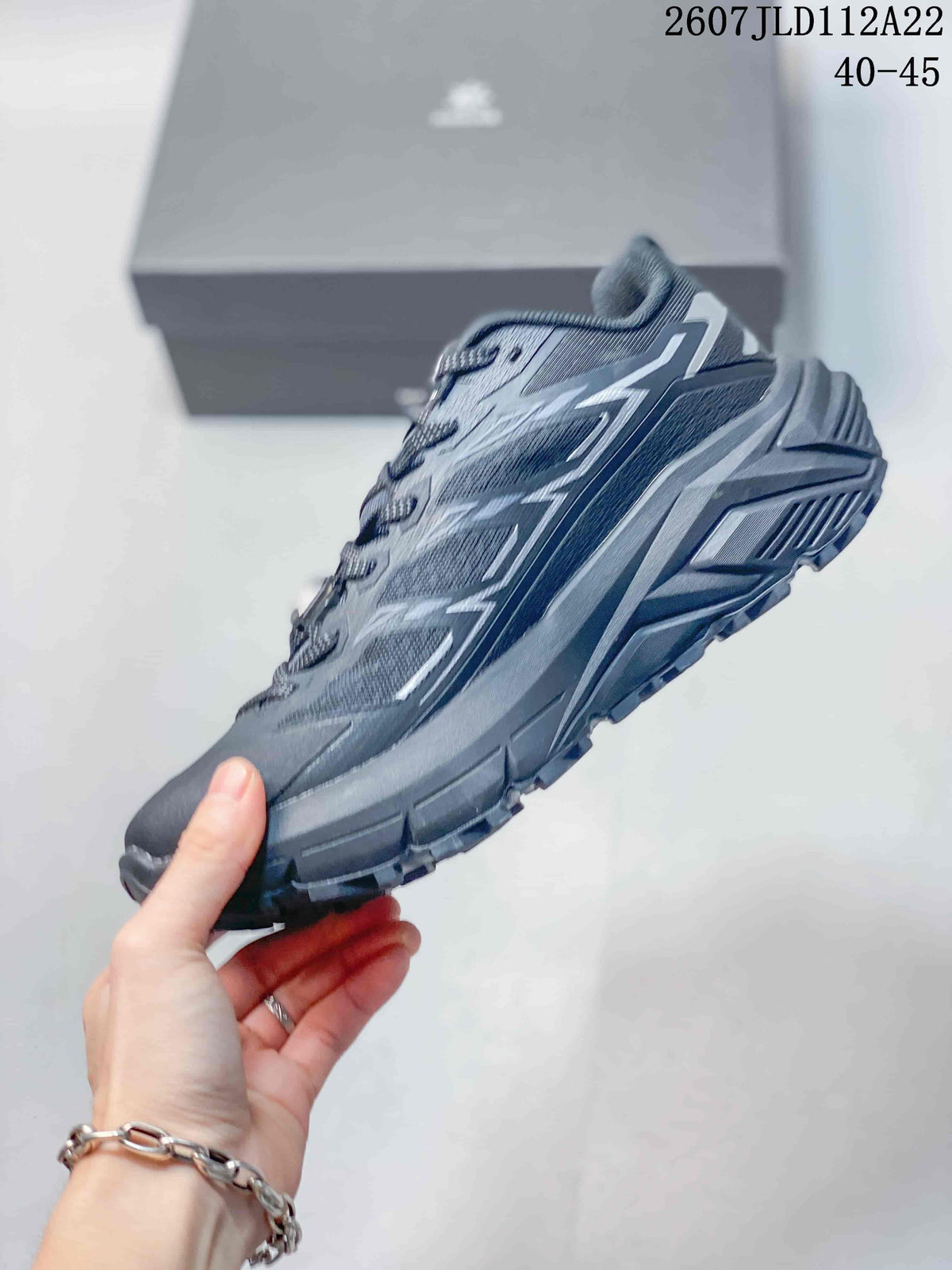 Side view of the dark gray trail shoe showing mesh panels, layered overlays, a structured midsole, and outdoor outsole; code 2607JLD112A22 and size range 40–45 are overlaid.