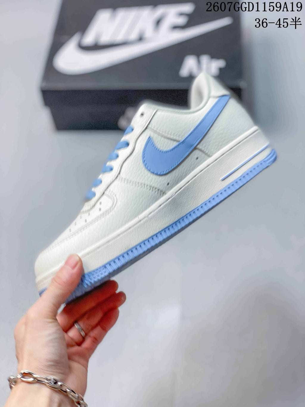 Side view of the white low-top sneaker with a light blue Swoosh, white midsole and light blue outsole.