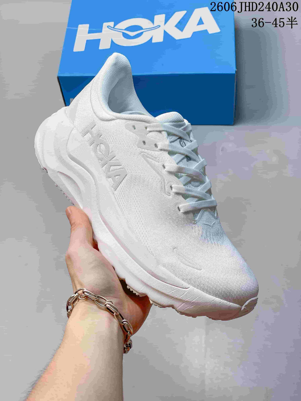 Angled side view of the white HOKA running shoe