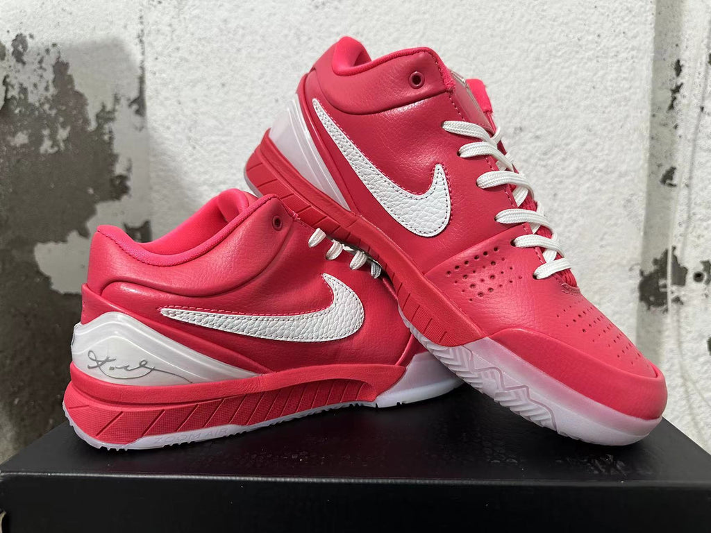 Pair of pink Nike Kobe basketball shoes displayed together, showing the white Swooshes and outsole.
