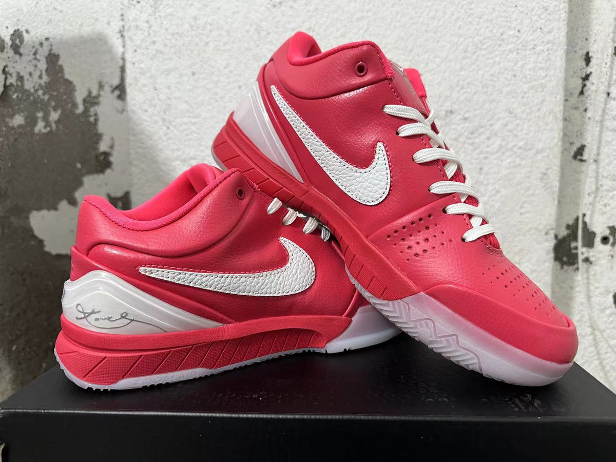Pair of pink Nike Kobe basketball shoes displayed together, showing the white Swooshes and outsole.