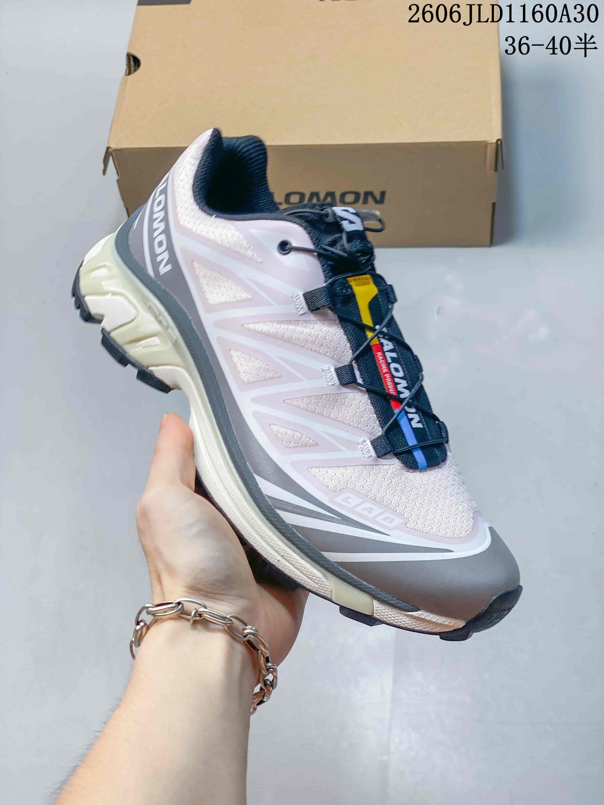 Side profile of the Salomon XT-6 sneaker in pink, gray, and navy