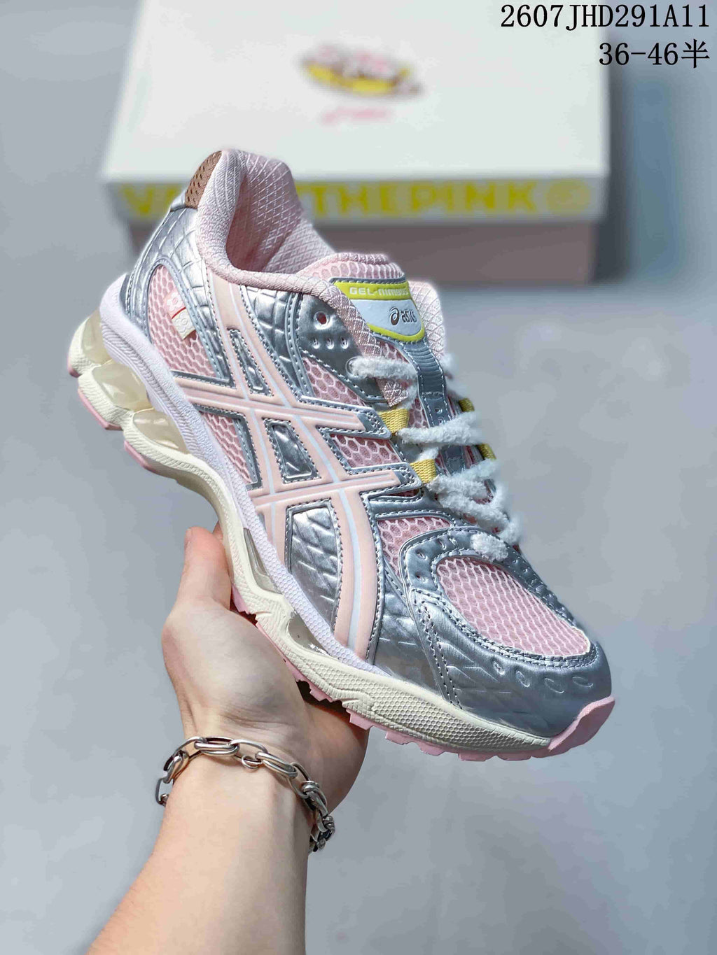 Angled side view of the silver and pink ASICS GEL-NIMBUS 10.1 sneaker showing the mesh upper, overlays, and outsole.