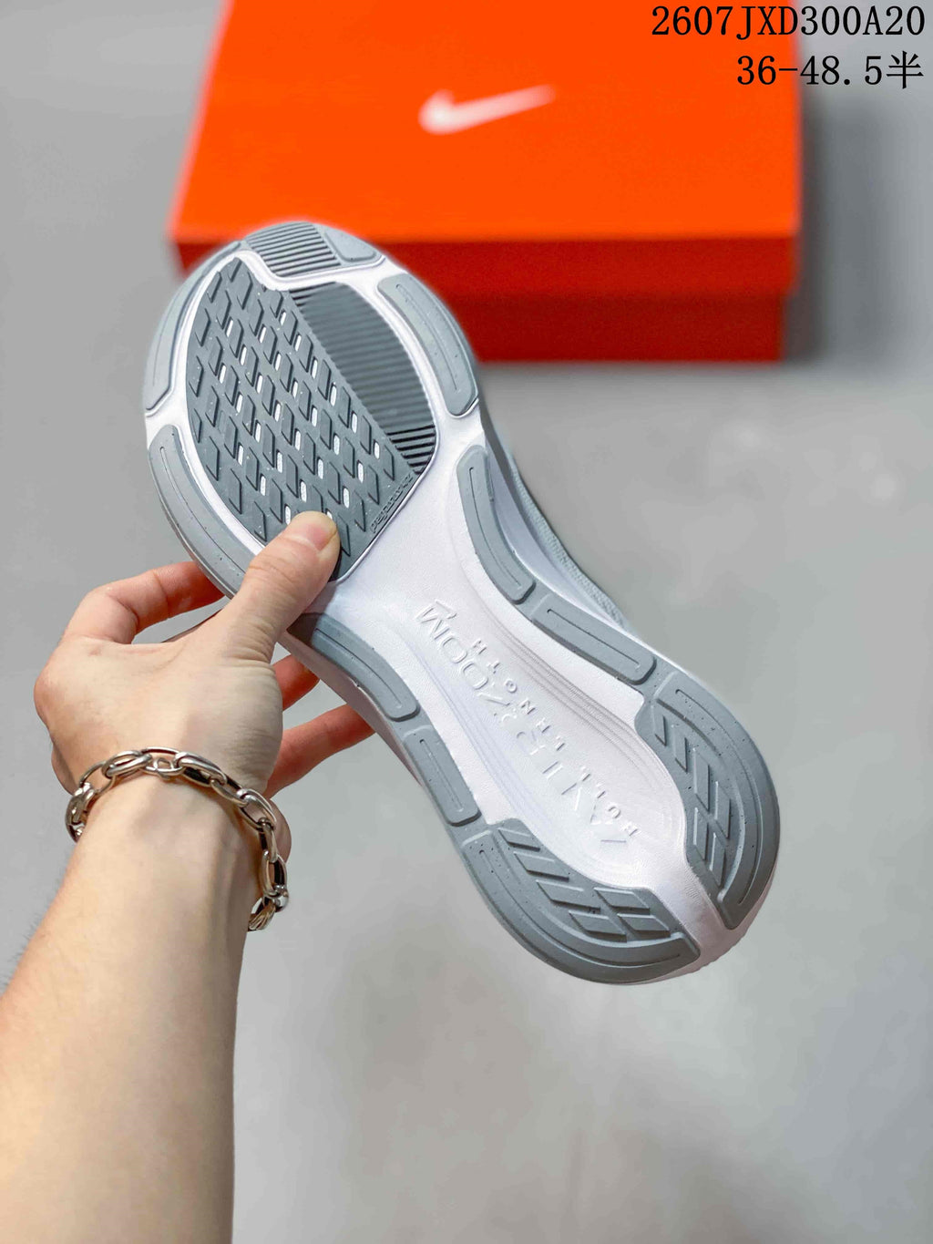Underside view of a white and gray sneaker showing the patterned outsole and molded sole details; image text shows size range 36–48.5.