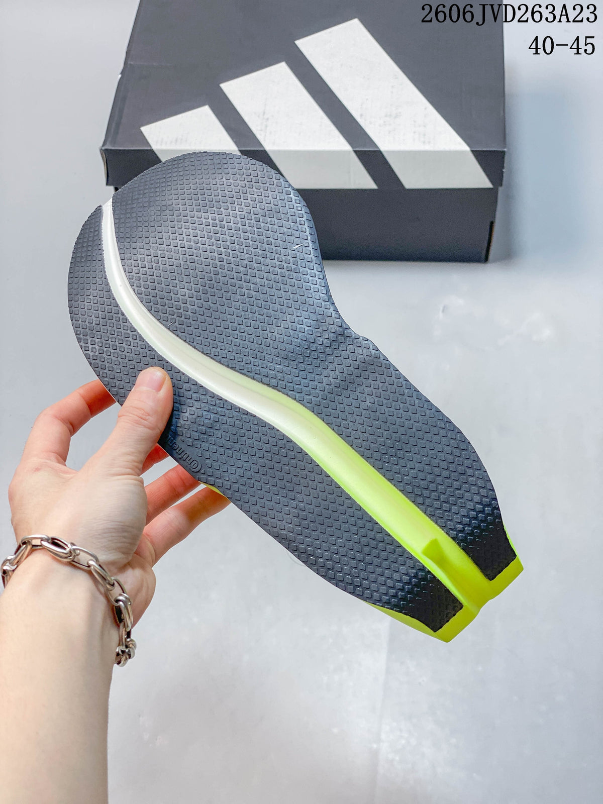 Close-up of the dark textured outsole with a bright neon-yellow central section.