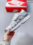 Side profile of the white and silver Nike P-6000 sneaker with layered panels and a low-top silhouette.