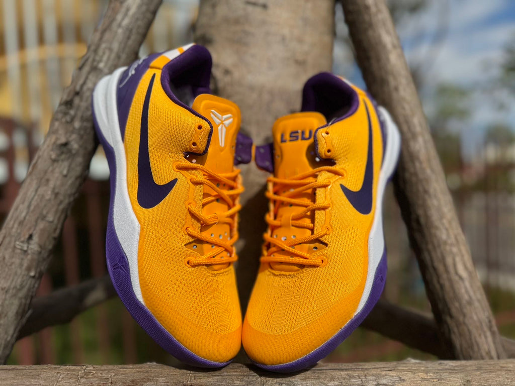 Front view of gold Kobe 8 shoes with LSU lettering on the tongue