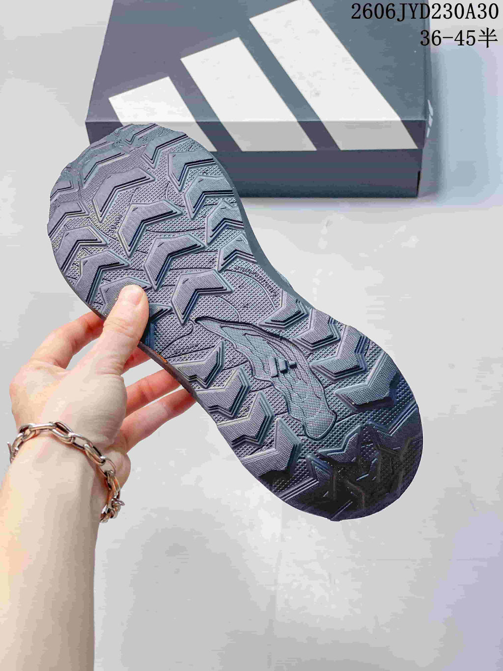 Close-up of the lugged outsole on a gray trail running shoe