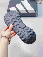 Close-up of the lugged outsole on a gray trail running shoe