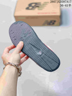 Close view of the dark textured outsole with circular tread details and New Balance branding.