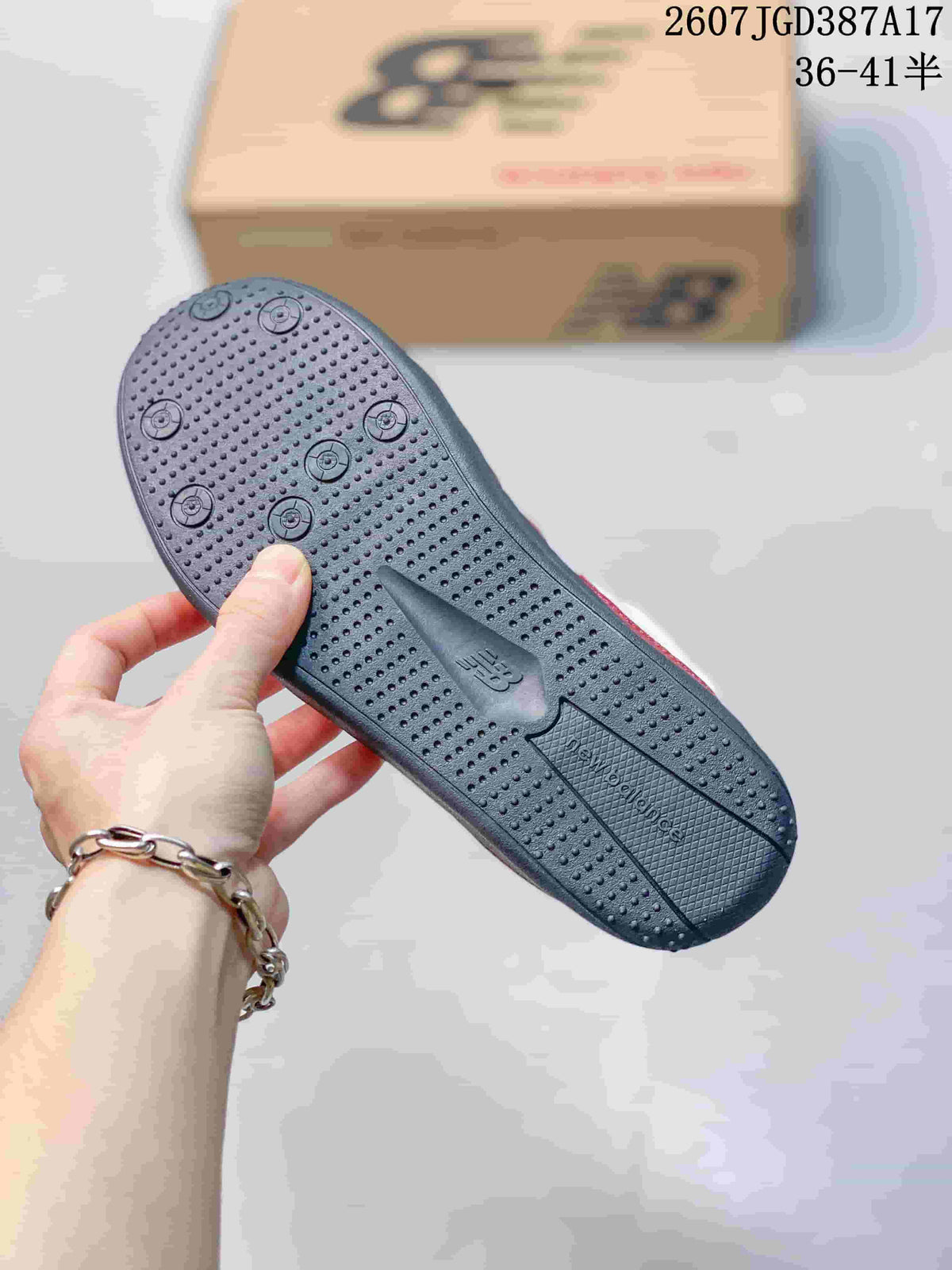 Close view of the dark textured outsole with circular tread details and New Balance branding.