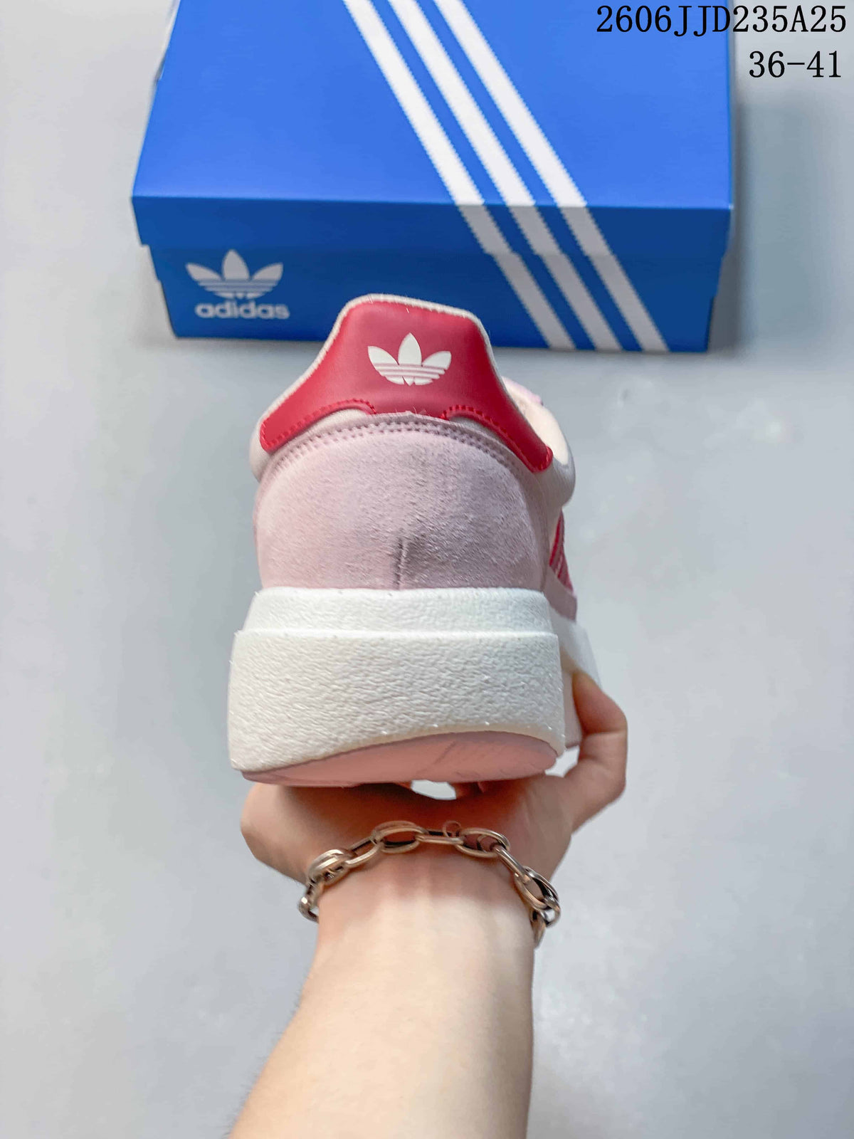 Rear view of the pink sneaker showing the red heel accent, white collar and raised white midsole.