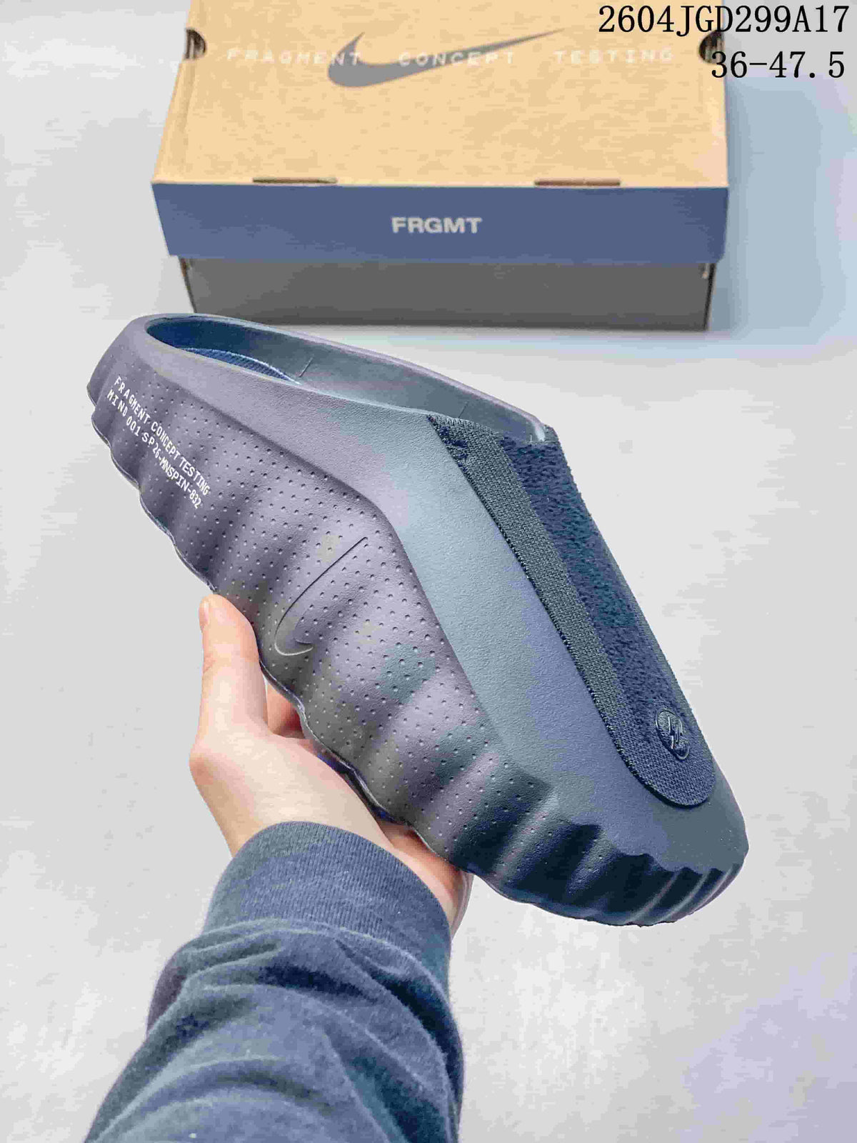 Side view of a dark blue-gray Nike Mind slide with perforated side panels and printed detailing.