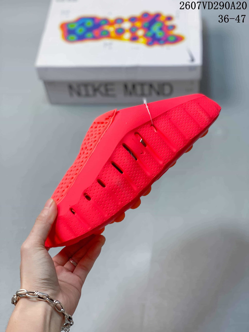 Side profile of the red slide showing perforations, ventilation openings, and a textured outsole.