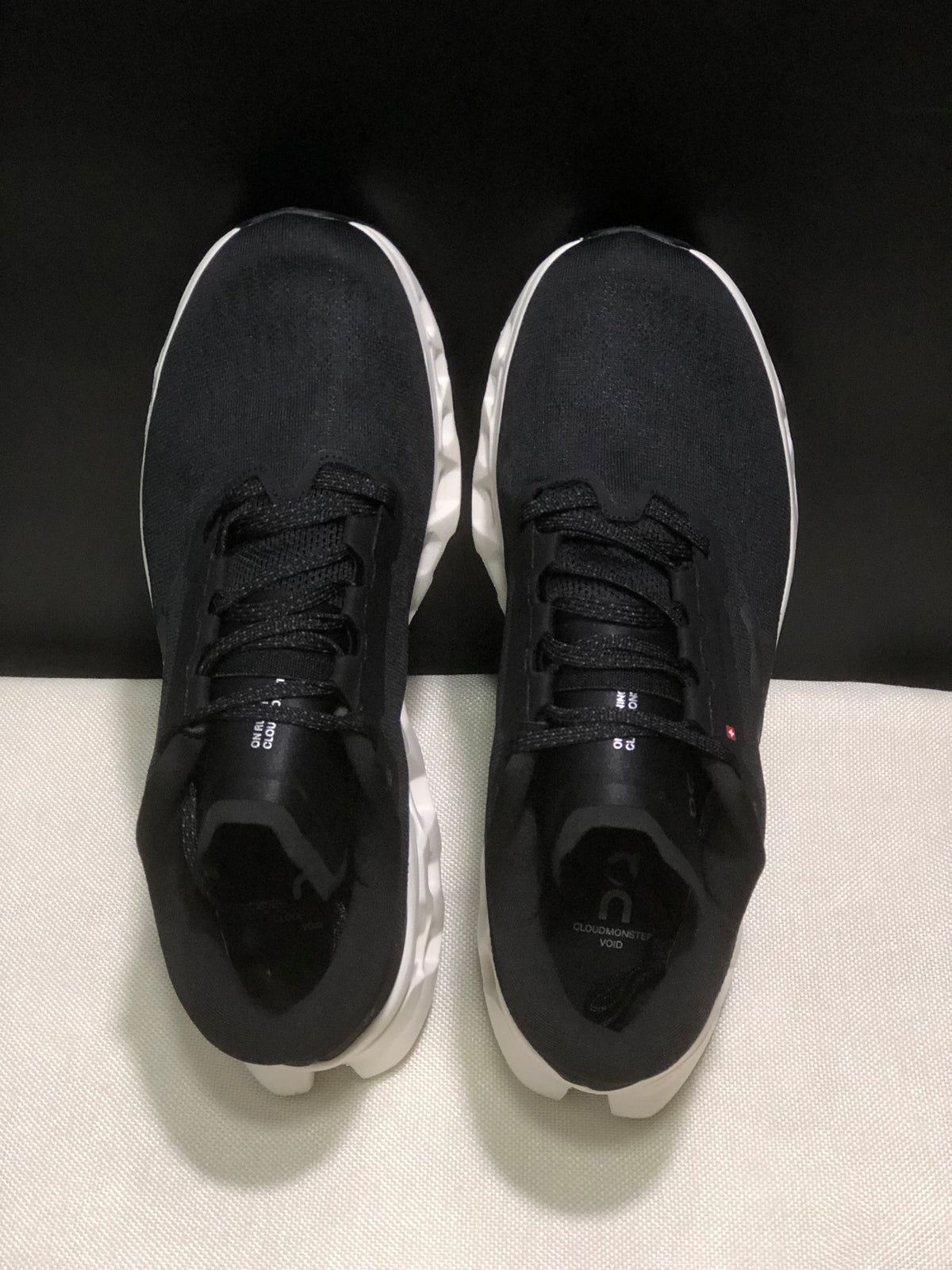 Top view of the pair showing black uppers, black laces, and padded tongues.