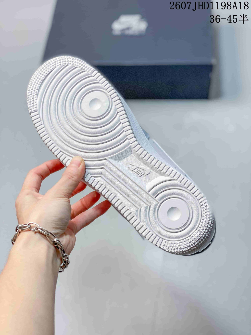 Close-up of the textured circular rubber outsole on a gray and white sneaker.