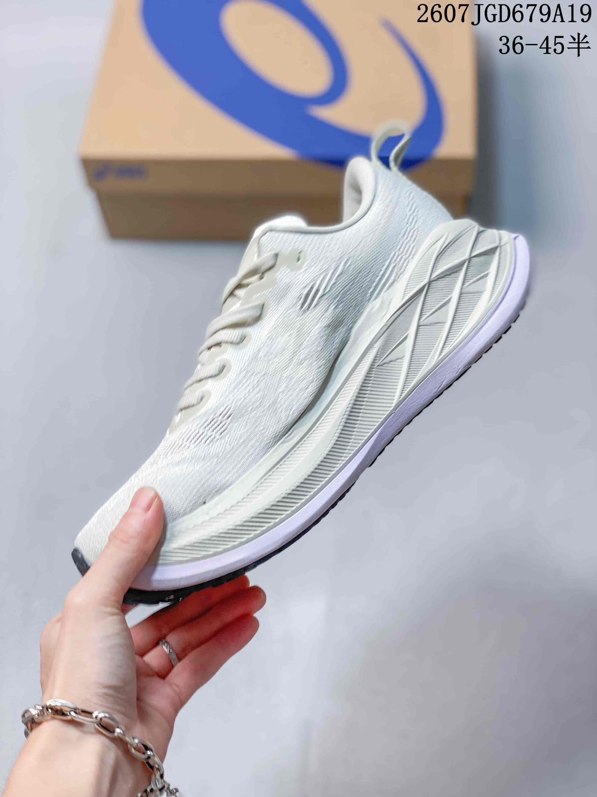 Side view of a white ASICS running sneaker showing the mesh-textured upper, lace area, layered midsole, and dark outsole edge.