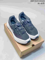 Pair of dark DESCENTE SHIELD Mantrix sneakers with white midsoles displayed on a shoebox.