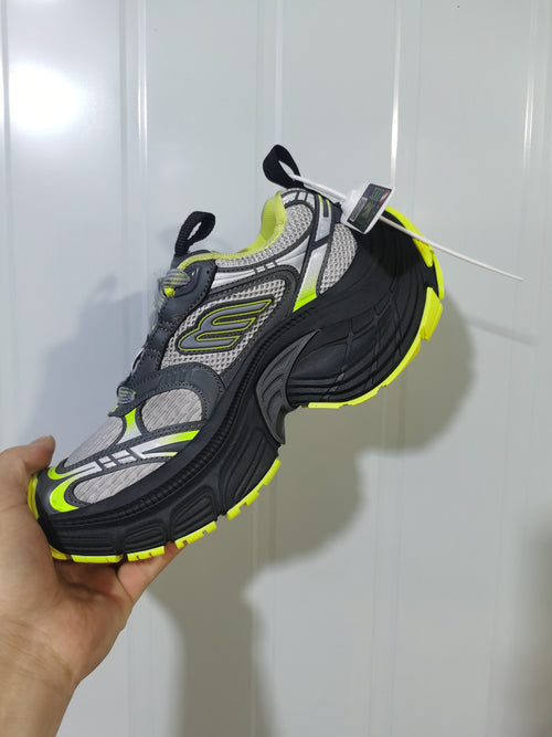 Second angled view showing the sneaker's textured-looking upper, padded collar, contrasting overlays and yellow outsole accents.