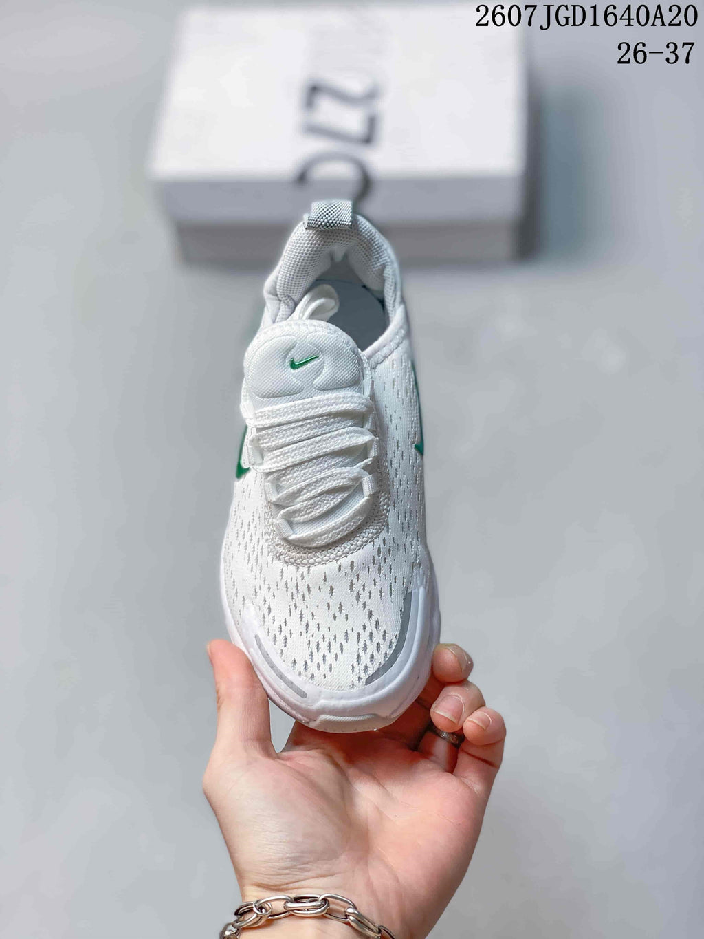Top view showing the white textured upper, lace-up fastening and green tongue logo.