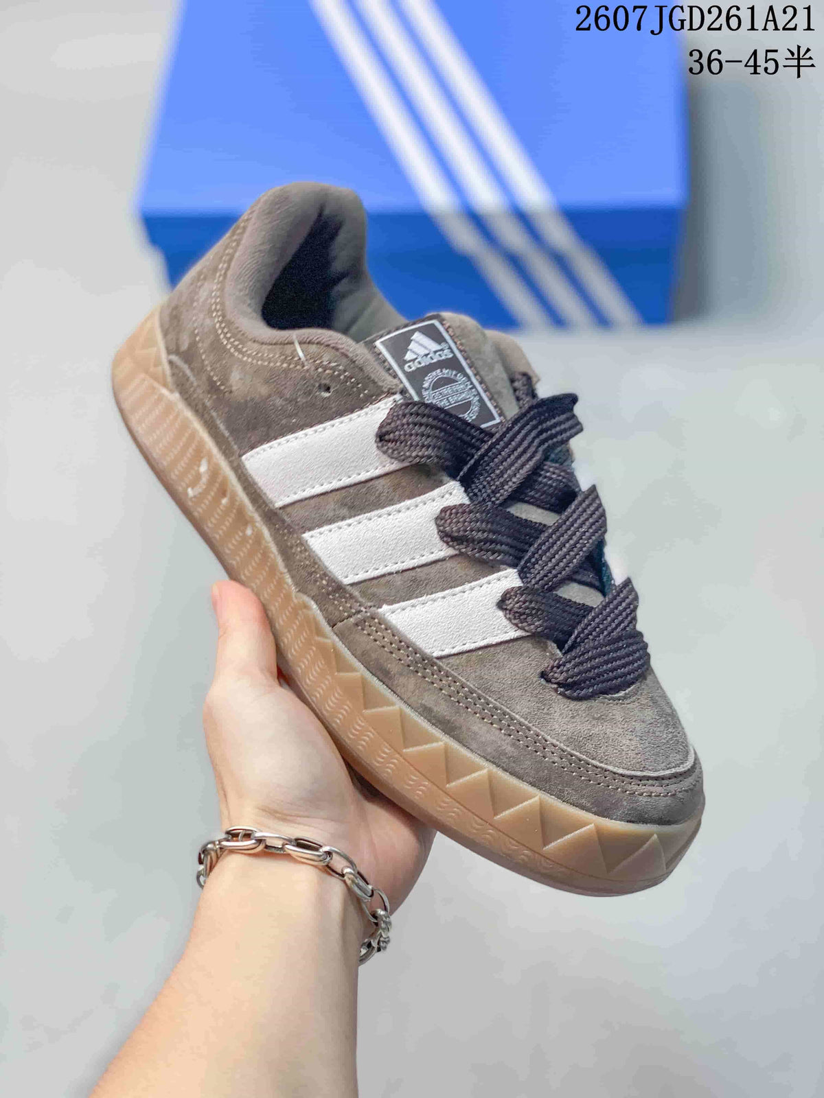 Angled side view of the Adidas Adimatic Low sneaker showing the brown upper, white stripes, dark laces, and gum outsole.