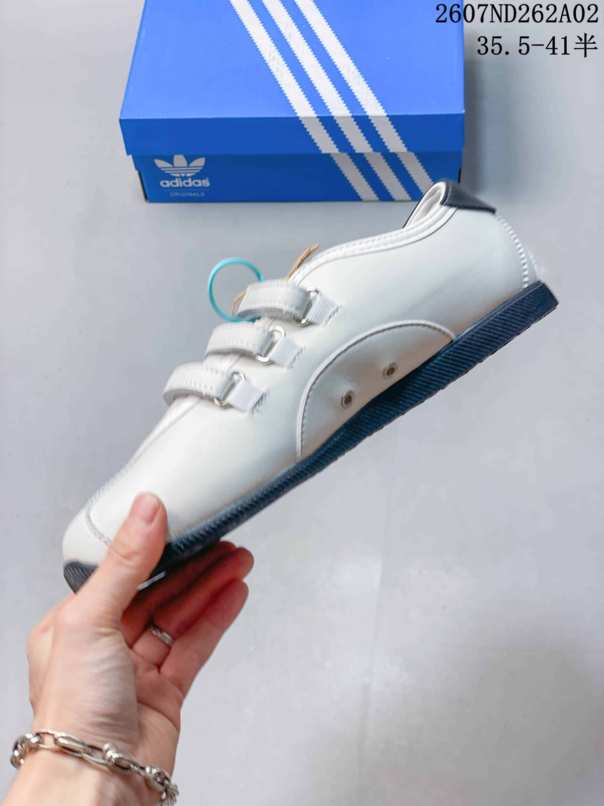 Side view showing the low-profile shape, three straps, and dark outsole