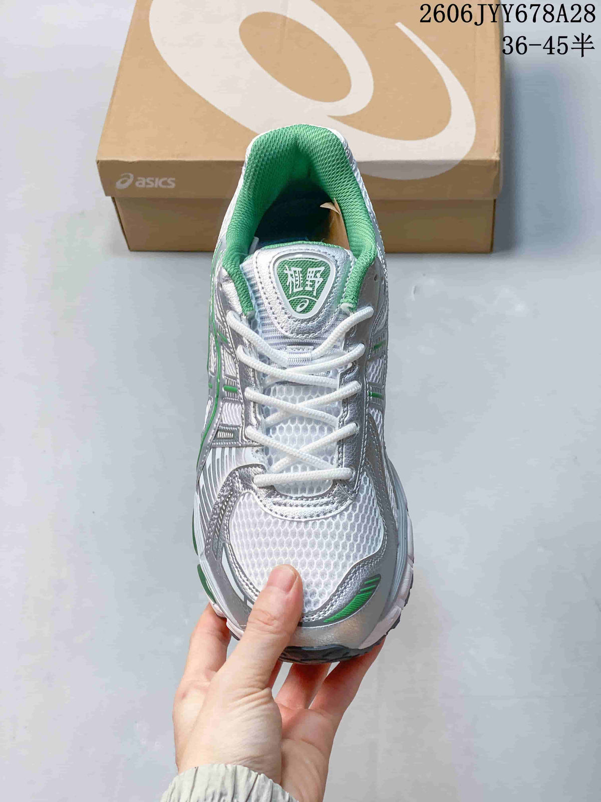 Top view of the shoe showing white laces, mesh-patterned toe, and green lining.