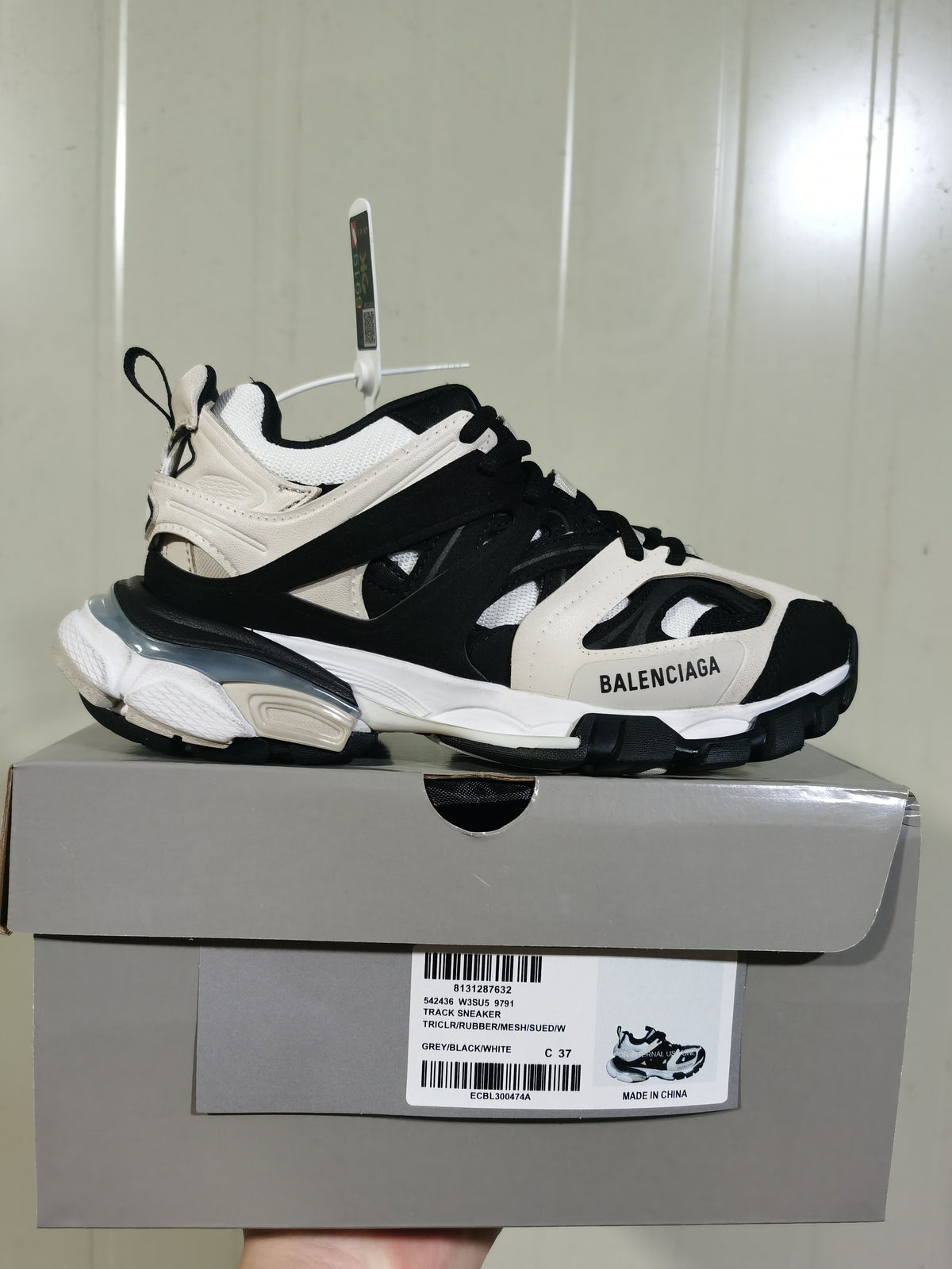Side view of the Balenciaga Track sneaker above its box; the label shows style code 542436 W3SU5 9791, color GREY/BLACK/WHITE, and size C 37.