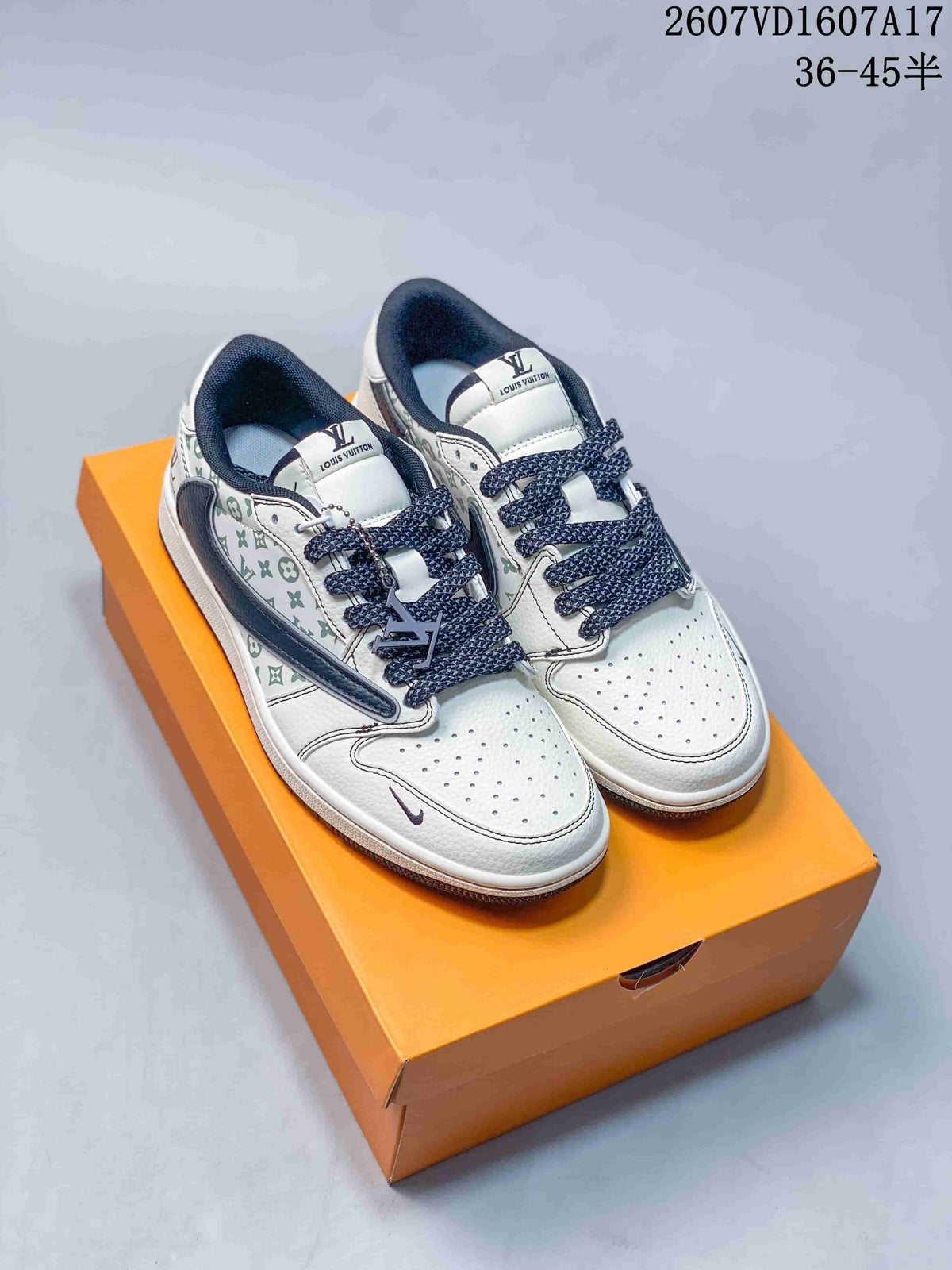 Pair of white low-top sneakers with navy laces, navy overlays, pale green monogram-style panels, and an orange shoebox.