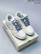 Pair of white and blue low-top sneakers displayed on a shoebox, with blue laces and style code 2607JVD1157A17 visible above.