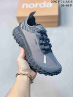 Angled side view of the gray Norda hiking sneaker showing the patterned upper, lace system, and rugged outsole.