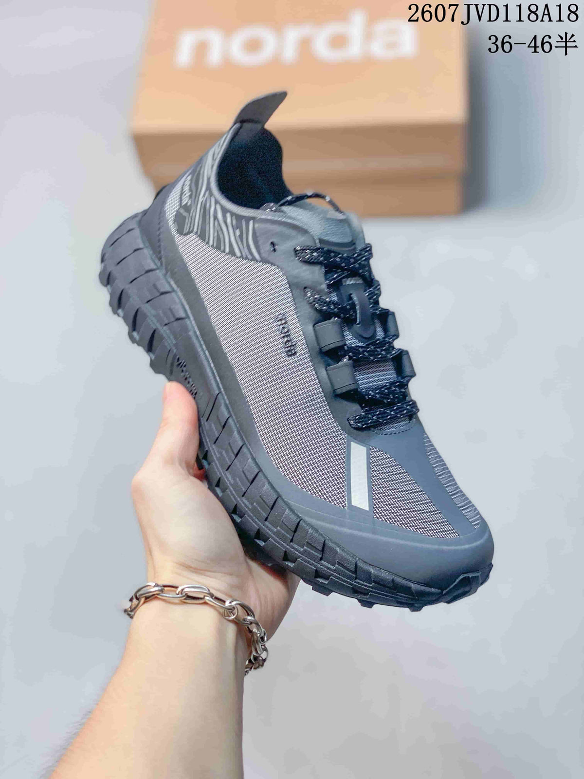 Angled side view of the gray Norda hiking sneaker showing the patterned upper, lace system, and rugged outsole.