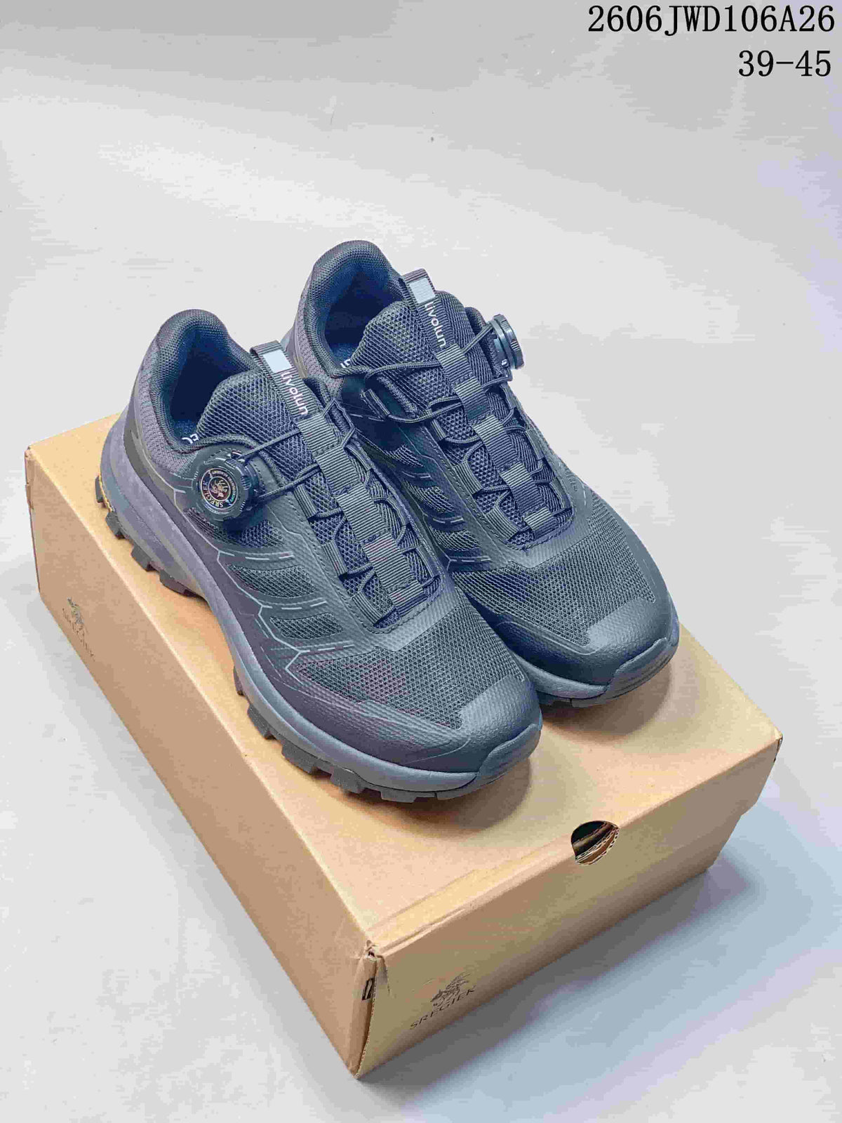 Pair of dark navy and gray SREGIEK sneakers with dial-style closures and treaded soles, displayed on a box.
