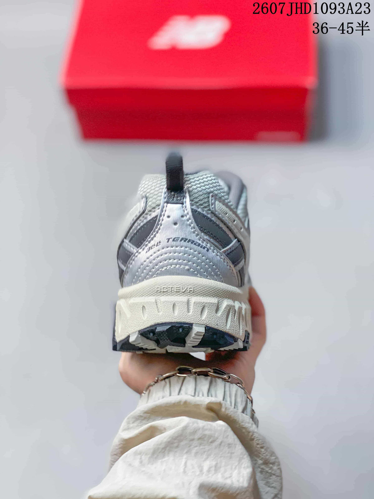 Rear view of the grey sneaker showing the padded heel, pull tab, layered construction, and lugged outsole.