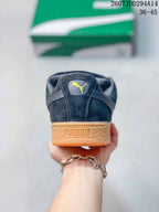 Rear view of a dark sneaker with a PUMA heel logo and gum-colored heel section.