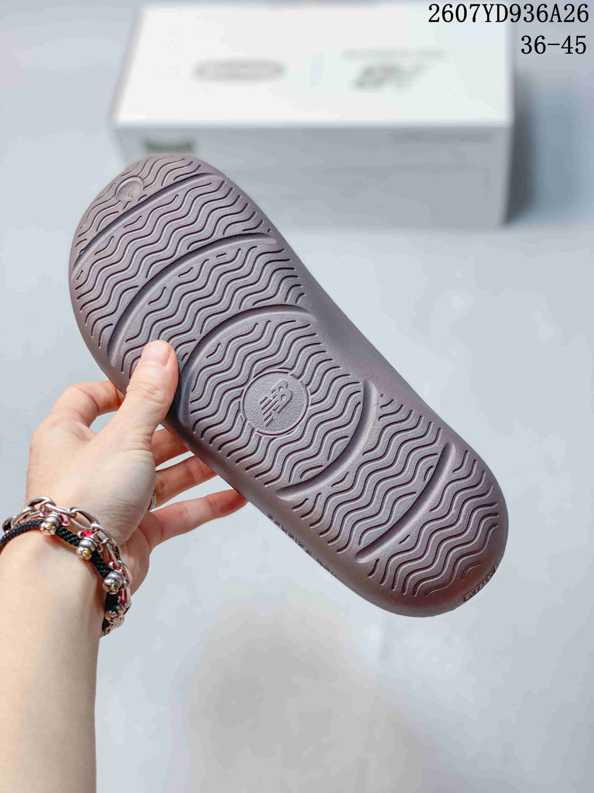 Close view of the sandal outsole showing a repeating wavy tread pattern and a central New Balance logo.